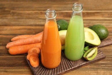 Bottles with tasty juices and ingredients on table