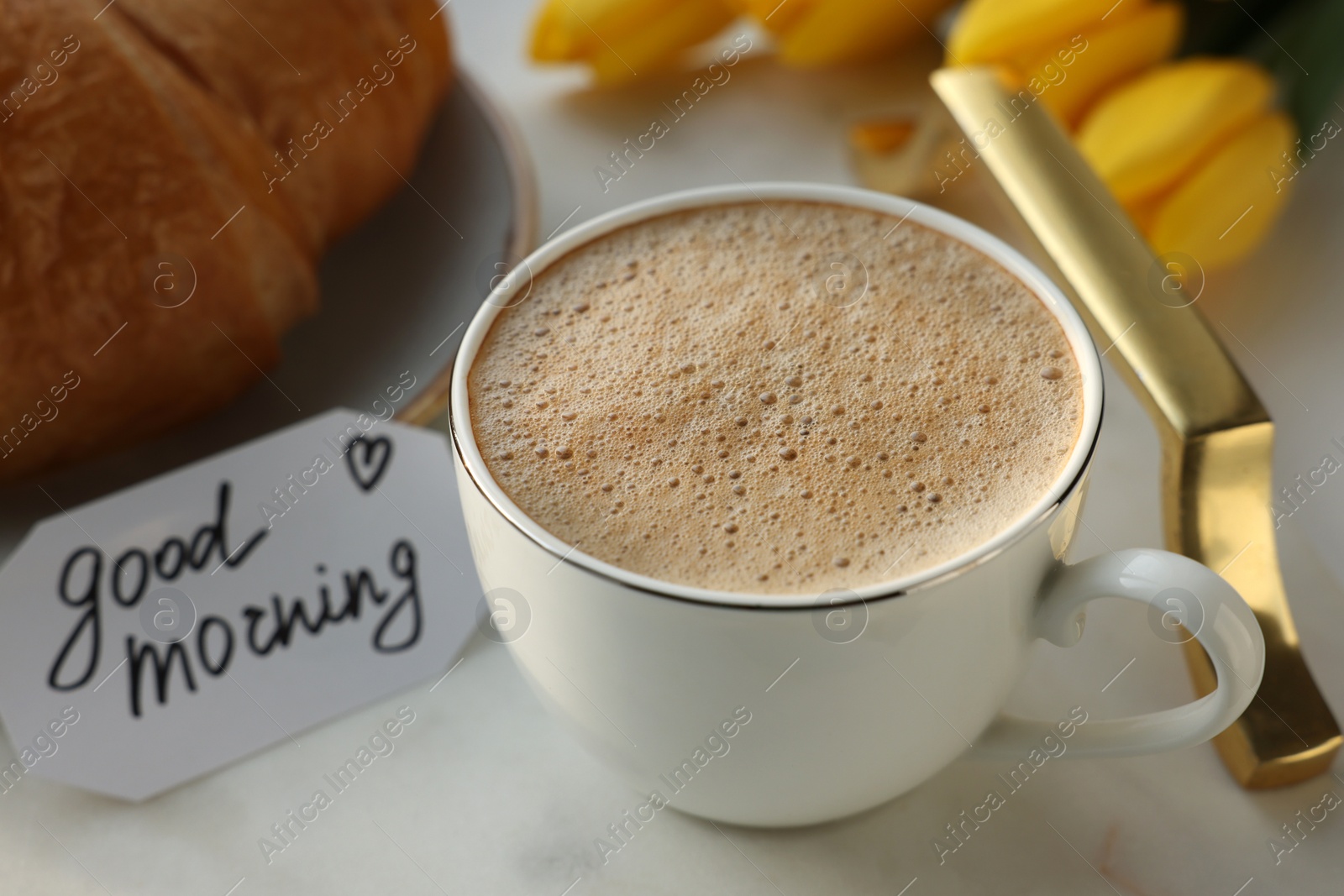 Photo of Cup of coffee, croissant and card with phrase GOOD MORNING on white tray, closeup