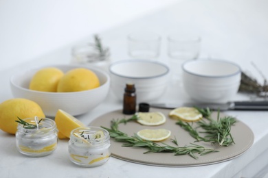 Natural homemade mosquito repellent candles and ingredients on white table