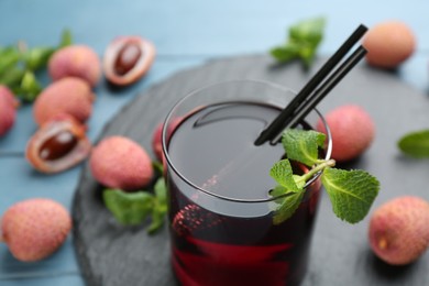 Photo of Delicious lychee cocktail with mint in glass on table, closeup