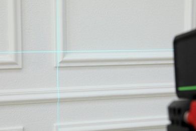 Cross lines of laser level on white wall