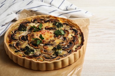 Delicious quiche with mushrooms and parsley on white wooden table, closeup