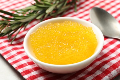 Photo of Fresh pike caviar in bowl and rosemary on table, closeup