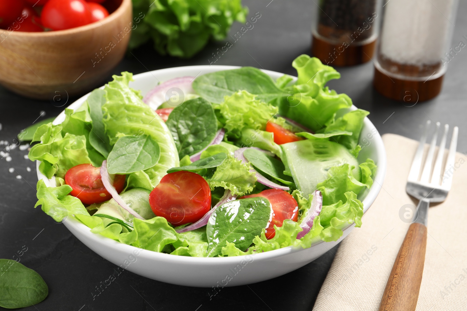 Photo of Delicious vegetable salad served on grey table, closeup