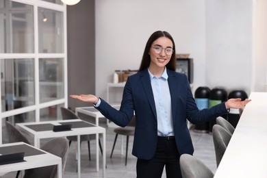 Happy female real estate agent in office