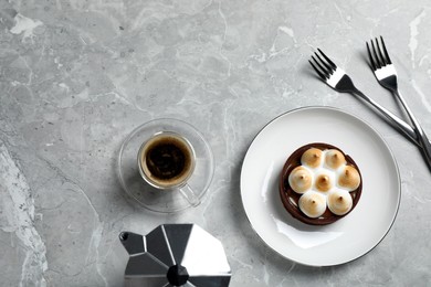 Delicious salted caramel chocolate tart with meringue and coffee on light grey marble table, flat lay