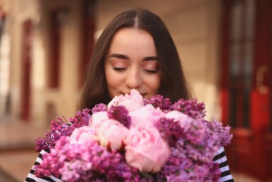 Photo of Beautiful woman with bouquet of spring flowers outdoors