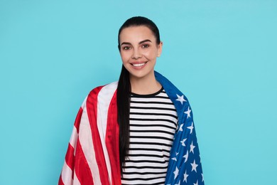 4th of July - Independence Day of USA. Happy woman with American flag on light blue background
