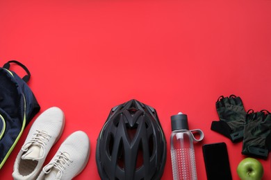Photo of Flat lay composition with different cycling accessories on red background, space for text