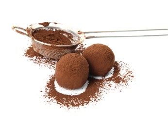 Photo of Delicious chocolate truffles and cocoa powder on white background