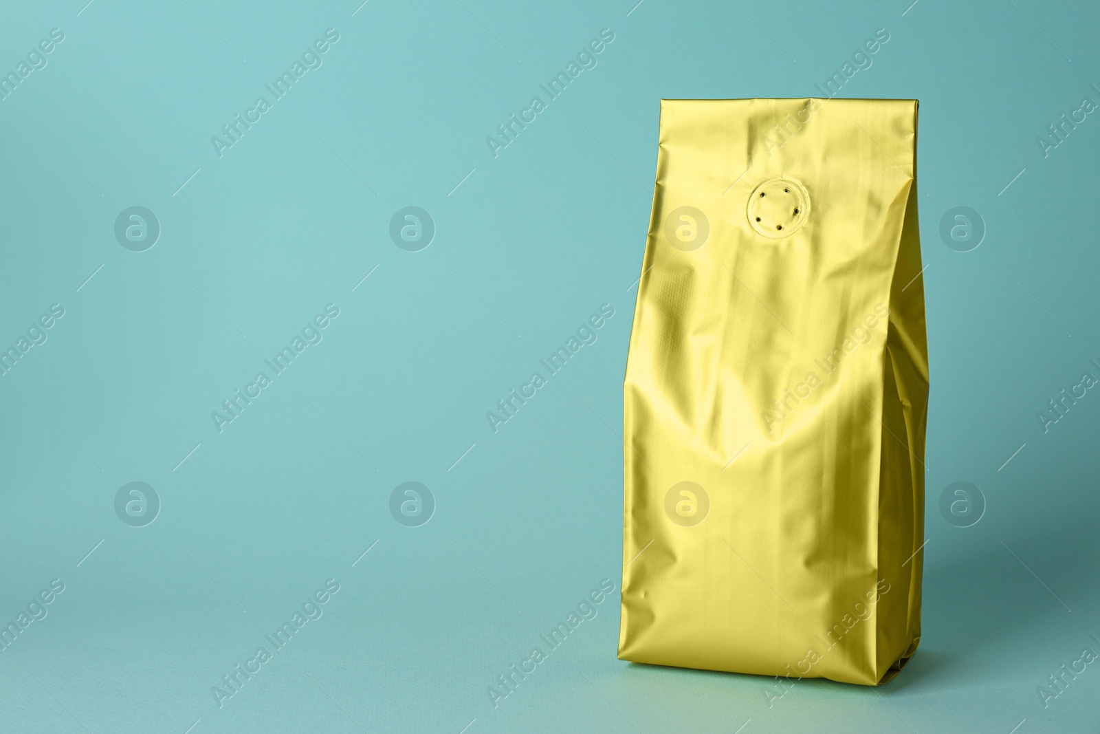 Photo of One blank foil package on light blue background. Space for text