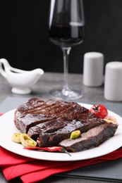 Delicious grilled beef meat served on grey table, closeup