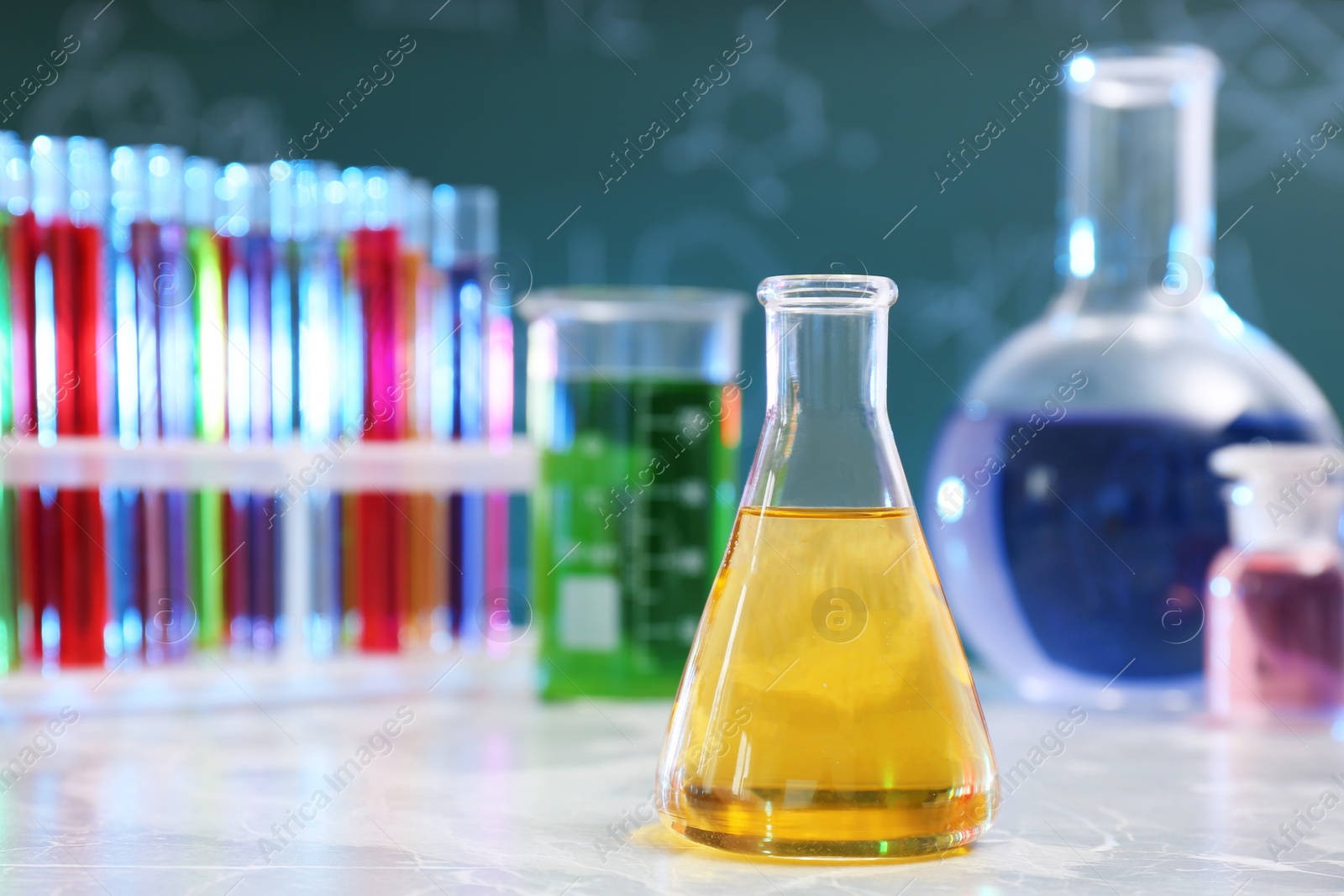 Photo of Conical flask on table against blurred background, space for text. Chemistry glassware