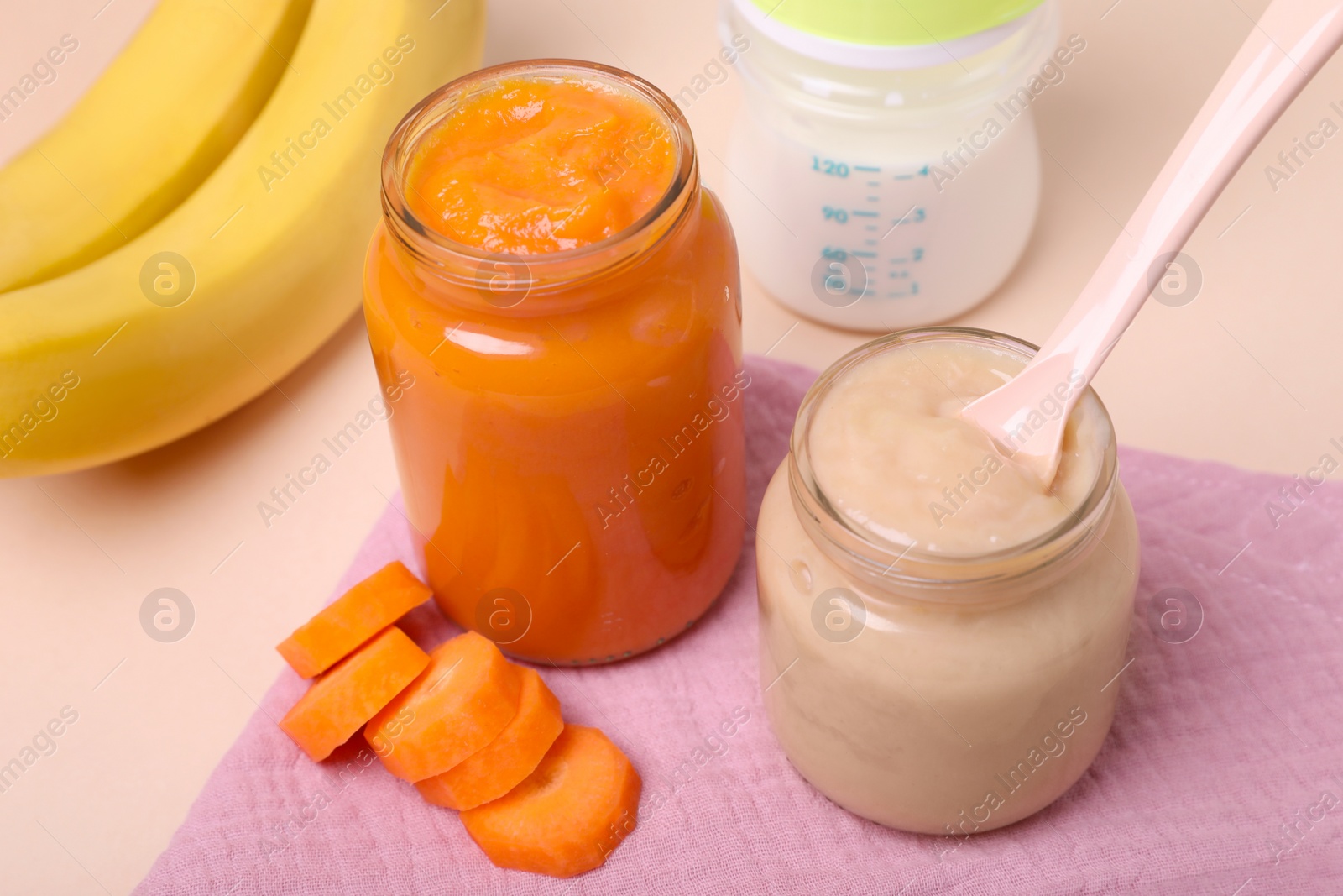 Photo of Healthy baby food, spoon and ingredients on pale pink background