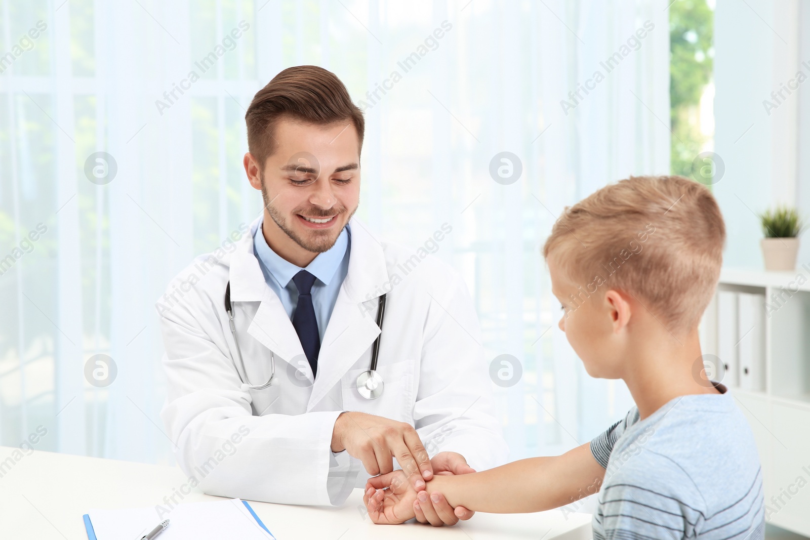 Photo of Doctor checking little boy's pulse in hospital