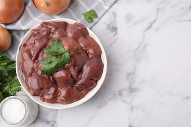 Photo of Bowl of raw chicken liver with parsley on white marble table, flat lay. Space for text