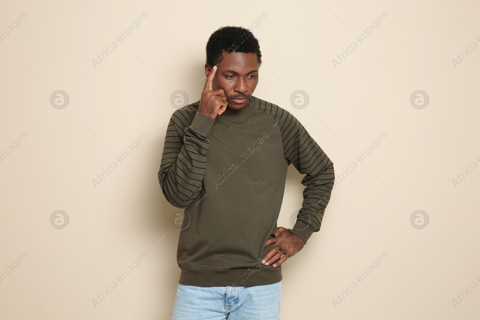 Photo of Portrait of thoughtful African-American man on color background