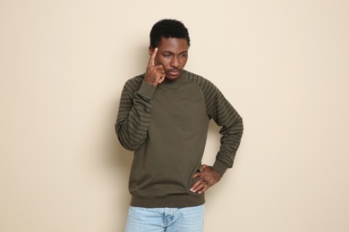 Portrait of thoughtful African-American man on color background