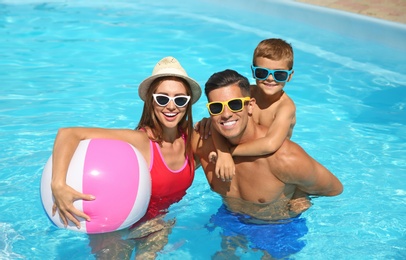 Photo of Happy family in swimming pool on sunny day