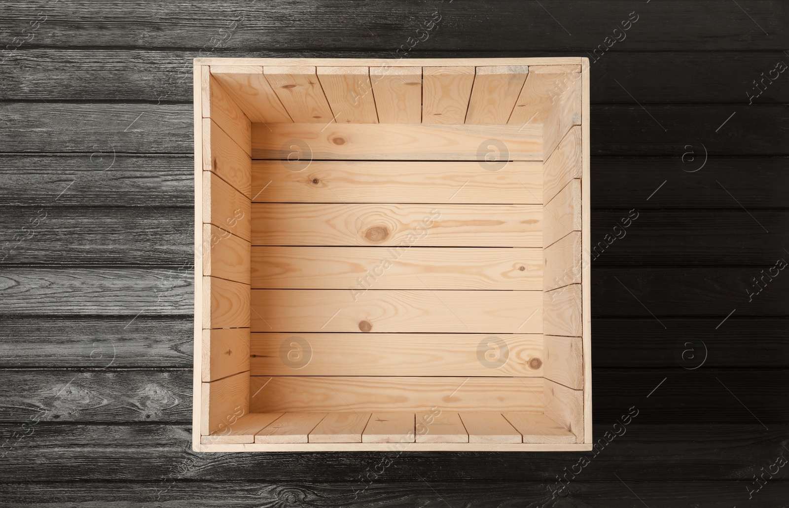 Photo of Open empty wooden crate on black background, top view