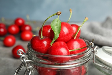 Glass jar with ripe sweet cherries on table, closeup