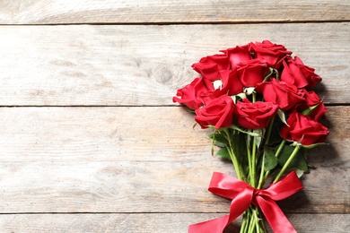 Photo of Beautiful red rose flowers on wooden background, top view