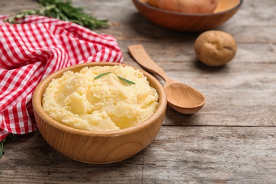 Photo of Bowl with tasty mashed potato on wooden table