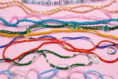 Beautiful handmade beaded necklaces on pink background