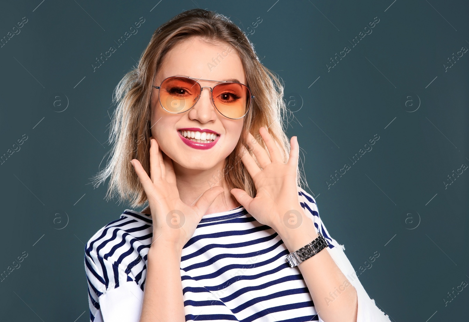 Photo of Beautiful young woman with sunglasses posing on color background