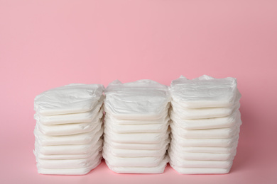 Photo of Stacks of baby diapers on pink background