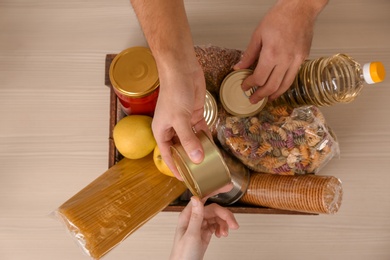 Photo of Volunteers taking food out of donation box on table, top view