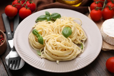 Photo of Delicious pasta with brie cheese and products served on wooden table, closeup