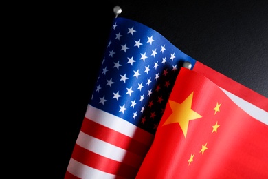 Photo of USA and China flags on black background, closeup