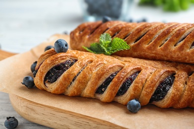 Fresh delicious puff pastry with sweet berries served on white wooden table, closeup