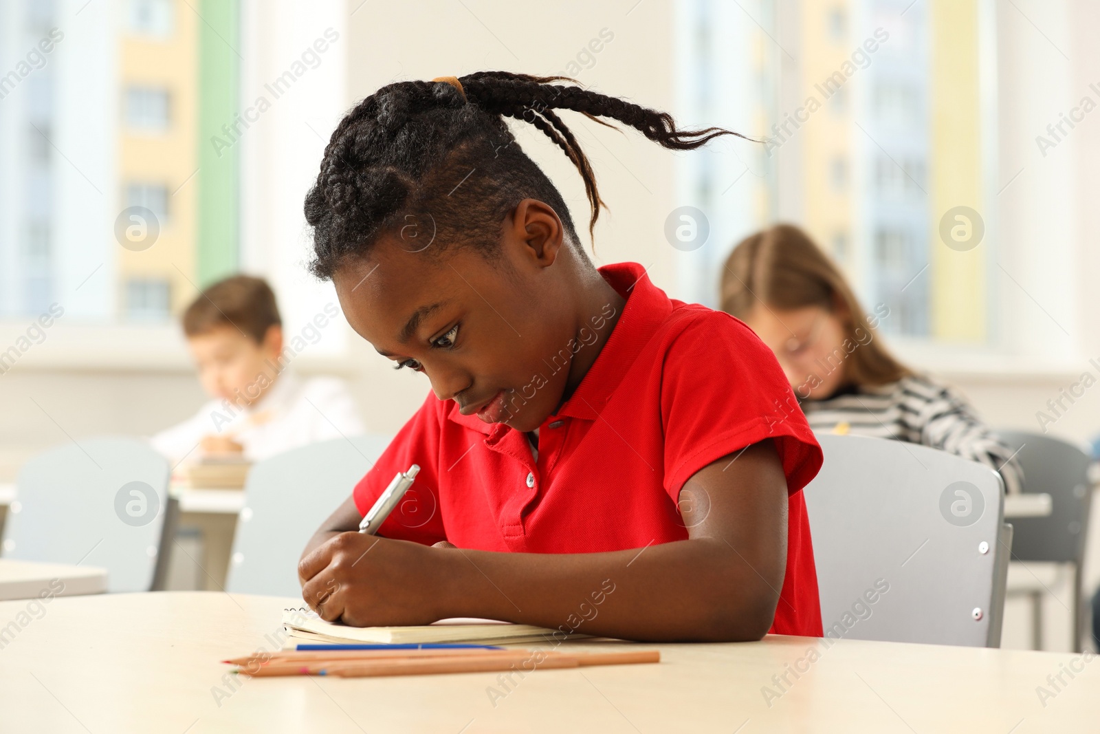 Photo of Portrait of cute little boy studying in classroom at school