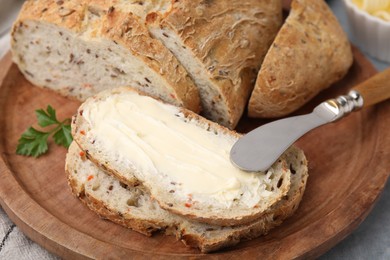 Tasty bread with butter and knife on grey table, closeup