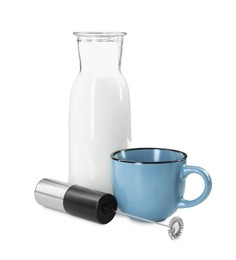 Photo of Milk frother wand, cup and glass carafe isolated on white