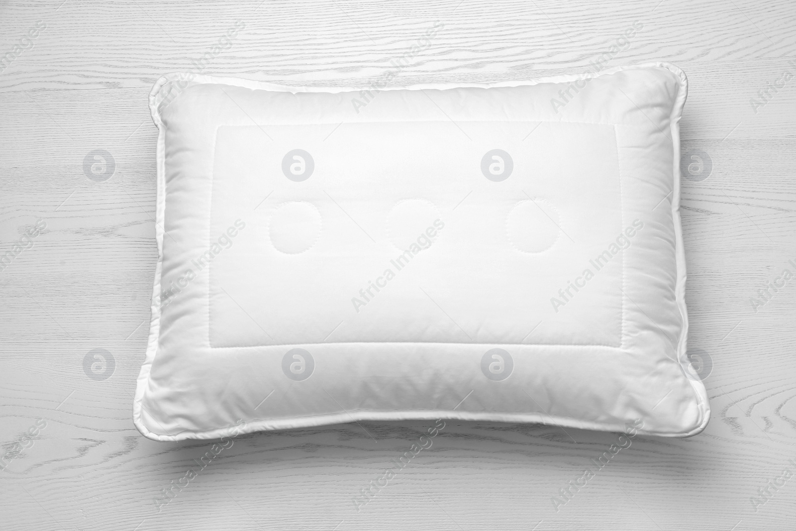 Photo of Soft bed pillow on wooden background, top view