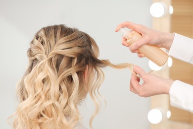 Hair styling. Professional hairdresser working with client in salon, closeup