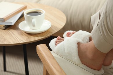 Photo of Woman wearing soft comfortable slippers at home, closeup