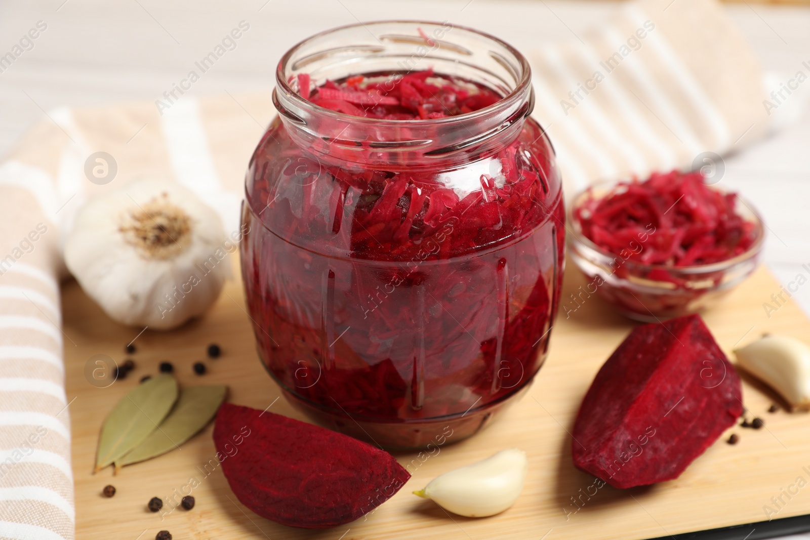 Photo of Jar with delicious pickled beetroot and spices on table, closeup