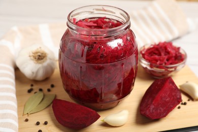 Jar with delicious pickled beetroot and spices on table, closeup