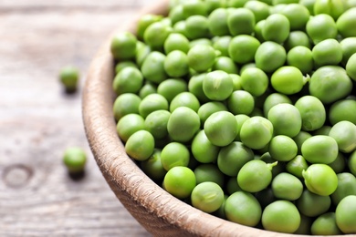 Photo of Bowl with delicious fresh green peas, closeup