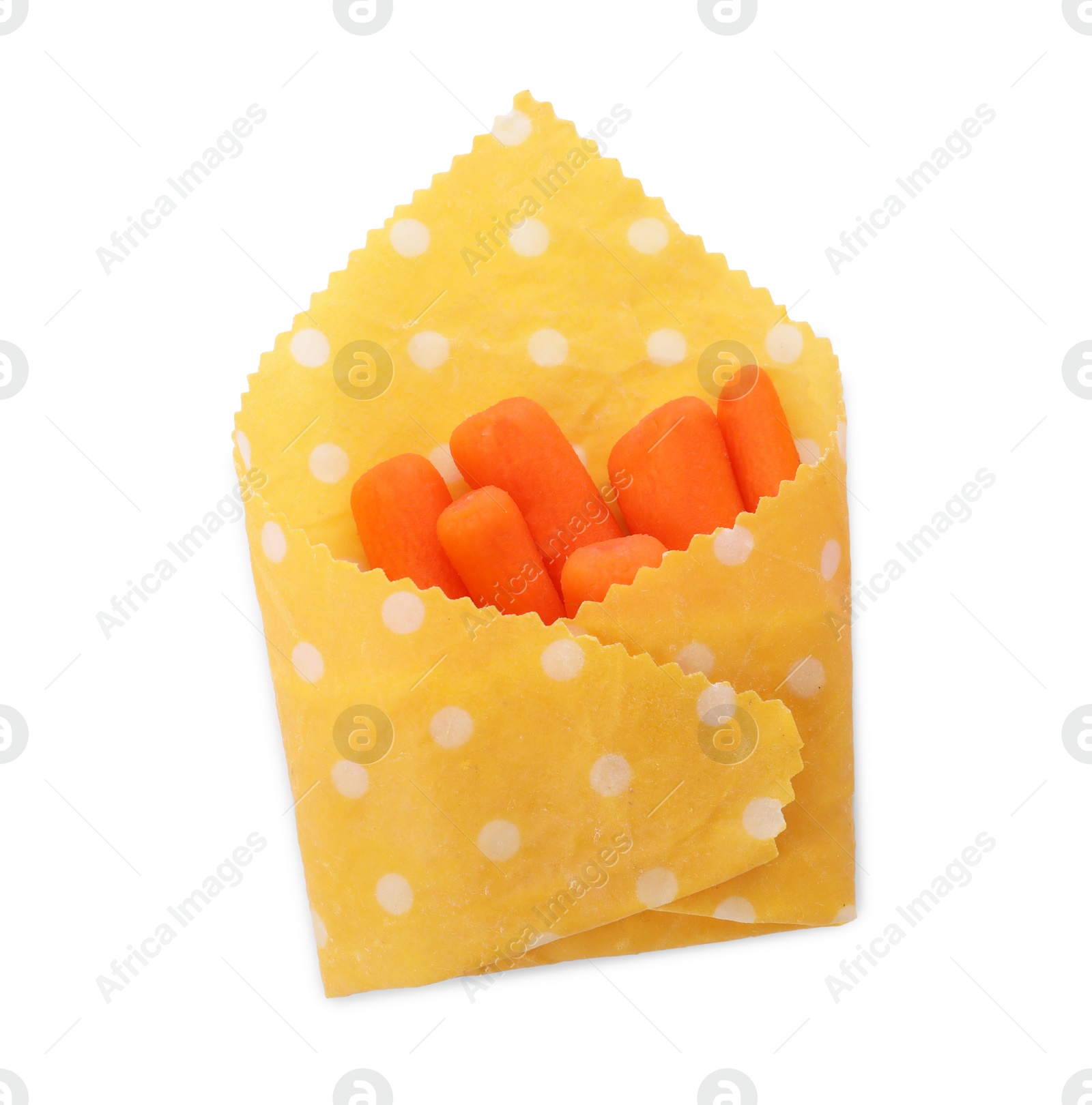 Photo of Many baby carrots in beeswax food wrap on white background, top view