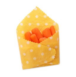 Photo of Many baby carrots in beeswax food wrap on white background, top view