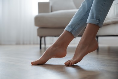 Photo of Barefoot woman at home, closeup. Floor heating system