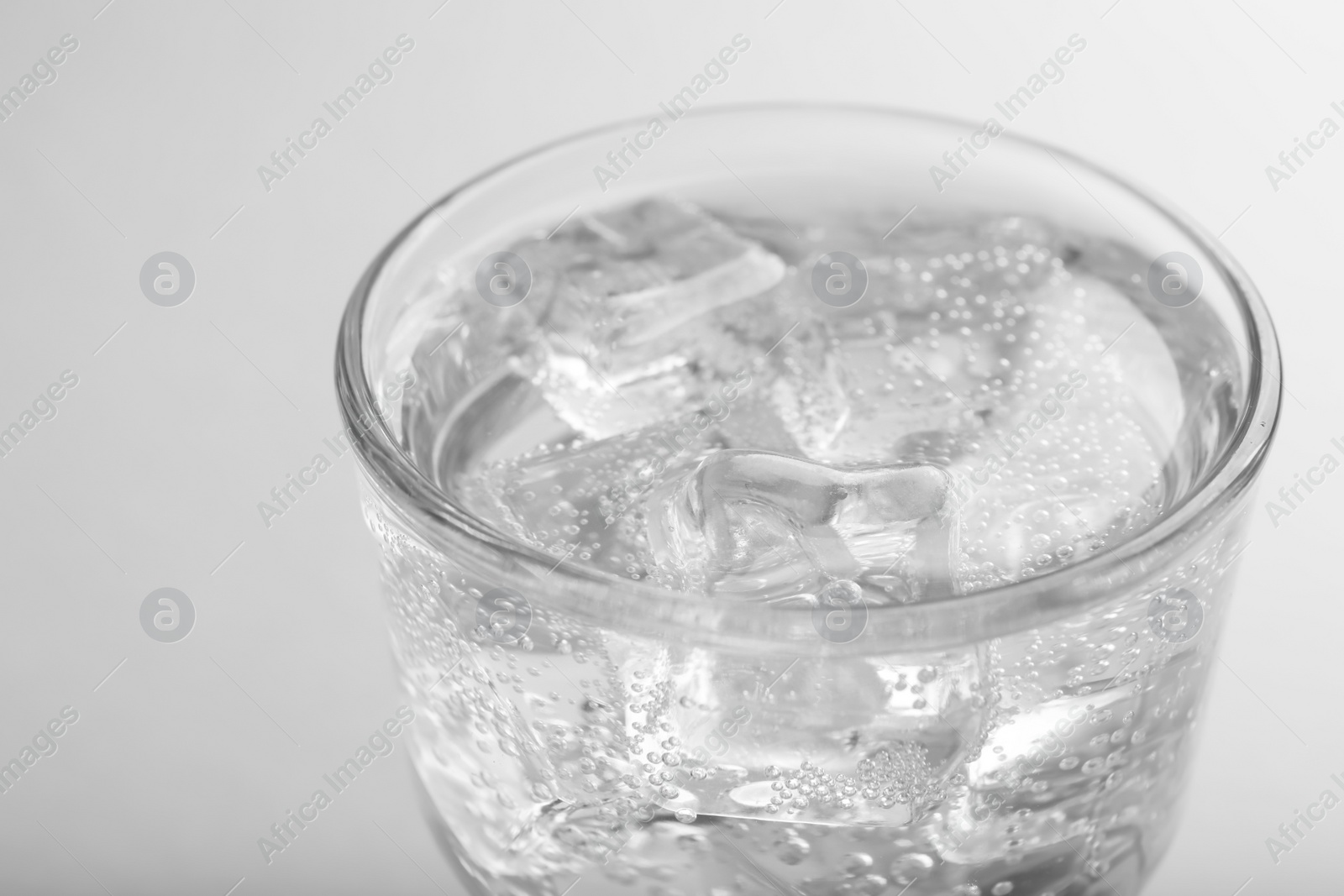 Photo of Glass of soda water with ice on white background, closeup