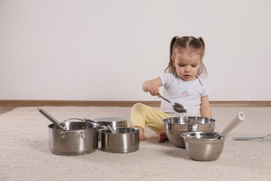 Cute little girl with cookware at home