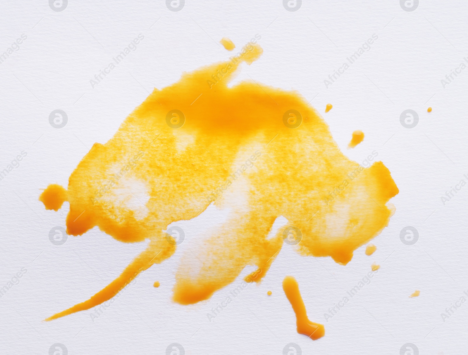 Photo of Blot of yellow ink on white background, top view