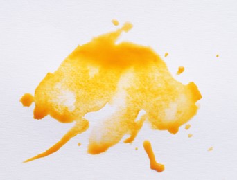 Photo of Blot of yellow ink on white background, top view
